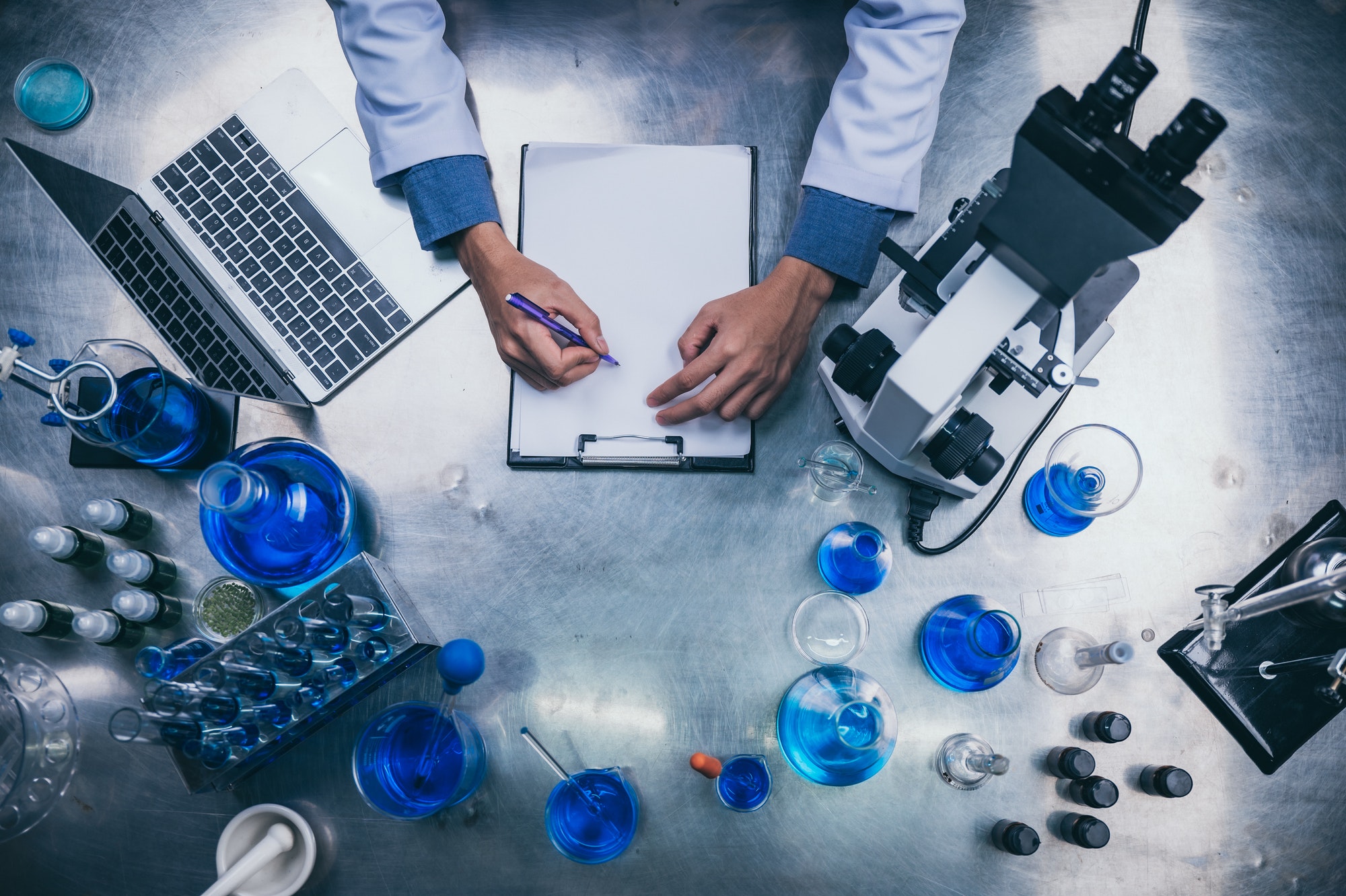 top view workspace in laboratory with microscope, laptop, and laboratory tools